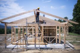 Builders working on wooden construction site, modern wooden house.