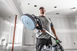 Man holding a sander.