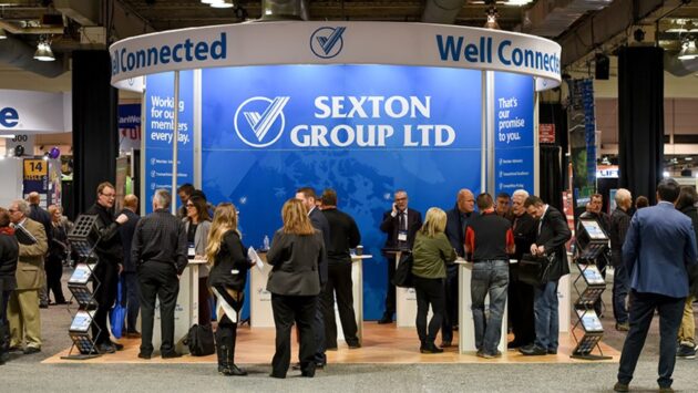 Photo of a group of Sexton employees in front of company sign. 